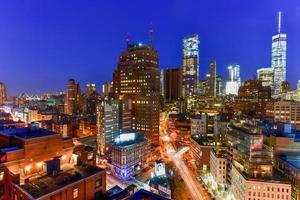 The skyline of downtown Manhattan, New York at sunset with trails of traffic in the street. photo