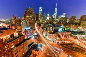 The skyline of downtown Manhattan, New York at sunset with trails of traffic in the street. photo