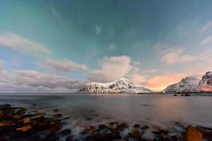 aurora boreal sobre el mar en la playa de skagsanden, islas lofoten, noruega en invierno. foto