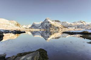 Boosen by Bo with mountains reflecting in the water. In the Lofoten Islands, Norway in the winter. photo