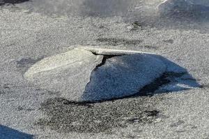 roca que se agrieta a través del hielo en boosen en las islas lofoten, noruega en el invierno. foto