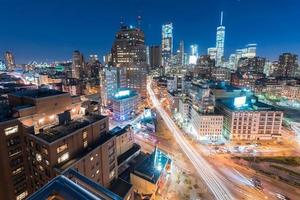 The skyline of downtown Manhattan, New York at sunset with trails of traffic in the street. photo