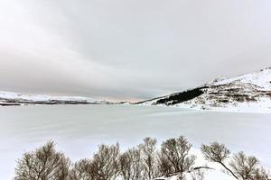 lago nevado ostadvatnet en las islas lofoten, noruega en invierno. foto