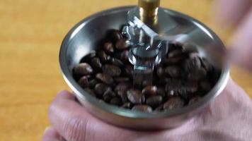 Mens slijpen koffie bonen gebruik makend van een handleiding hand- koffie Slijper video