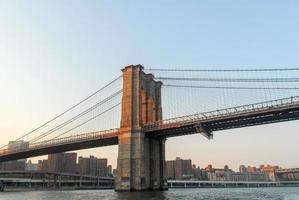 Brooklyn Bridge against the New York skyline at sunset photo