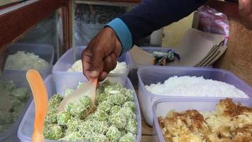 Klepon ist ein beliebter traditioneller indonesischer Snack, der aus klebrigem Reismehl hergestellt wird, das zu kleinen Kugeln geformt und mit braunem Zucker gefüllt wird. traditionelles indonesisches Essen. video