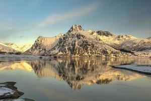 montañas reflejadas en un lago en flakstadoya en las islas lofoten, noruega foto