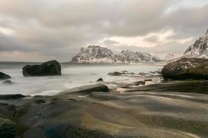 Waves flowing over Utakleiv Beach, Lofoten Islands, Norway in the winter. photo