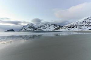 playa haukland en las islas lofoten, noruega en invierno al atardecer. foto