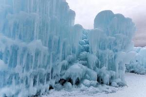 Translucent blue icicles in a frozen ice wall. photo