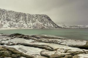 playa haukland en las islas lofoten, noruega en invierno al atardecer. foto