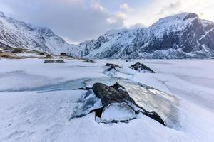Rocks breaking through the ice at Eggum, Lofoten Islands, Arctic, Norway, Scandinavia, Europe on a cloudy, winter day. photo