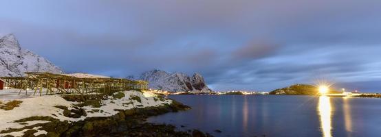 Winter in Reine, Lofoten Islands, Norway. Stocks for drying fish at night. photo