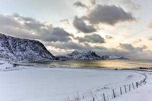 playa haukland en las islas lofoten, noruega en invierno al atardecer. foto