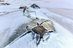 Rocks breaking through the ice at Eggum, Lofoten Islands, Arctic, Norway, Scandinavia, Europe on a cloudy, winter day. photo