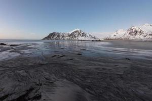 playa skagsanden en las islas lofoten, noruega en invierno al atardecer. foto