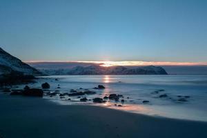 playa vikten en las islas lofoten, noruega en invierno al atardecer. foto