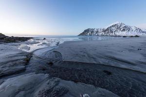 playa skagsanden en las islas lofoten, noruega en invierno al atardecer. foto