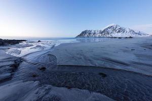 playa skagsanden en las islas lofoten, noruega en invierno al atardecer. foto