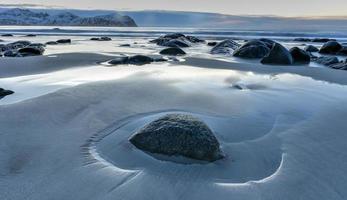 playa vikten en las islas lofoten, noruega en invierno al atardecer. foto