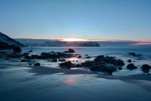 playa vikten en las islas lofoten, noruega en invierno al atardecer. foto