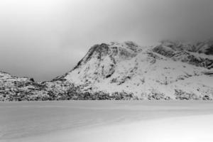 lago storvatnet frente al paisaje de las montañas lofoten en la isla flakstadoy en invierno. foto