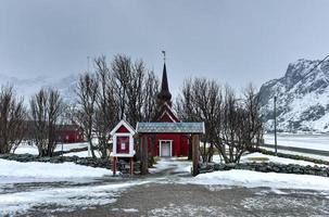 pintoresca antigua iglesia roja en flakstad en las islas lofoten, noruega en el invierno. foto