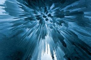 carámbanos azules translúcidos en una pared de hielo congelado. foto