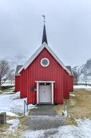 pintoresca antigua iglesia roja en flakstad en las islas lofoten, noruega en el invierno. foto