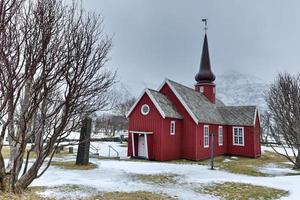 pintoresca antigua iglesia roja en flakstad en las islas lofoten, noruega en el invierno. foto