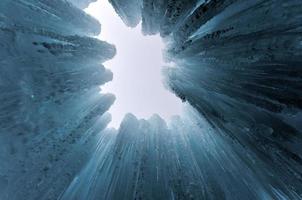 Translucent blue icicles in a frozen ice wall. photo