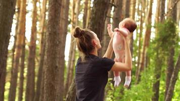 giovane mamma giochi con un' poco bambino ragazza nel il boschi video