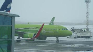 novosibirsk, federación rusa 14 de noviembre de 2020 - s7 airlines airbus a320, vp bwt airliner rodando antes de la salida en clima nevado en el aeropuerto internacional de tolmachevo, novosibirsk video