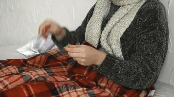 mulher com um suéter com um termômetro na mão deitada na cama