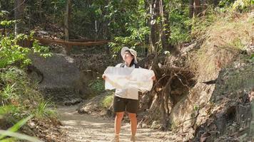 geóloga feminina usando um mapa, examinando um caminho natural e analisando rochas ou cascalho. pesquisadores coletam amostras de materiais biológicos. pesquisa ambiental e ecológica. video