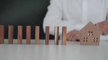 Versicherung mit Händen schützen Domino. geschäftsmannhände stoppen dominosteine, die in geschäftskrisen fallen. Kontrolle und Planung von Geschäftsrisiken sowie Strategien zur Führung von Versicherungsgeschäften. video