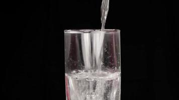 Pour clear drinking water into a glass of water. video