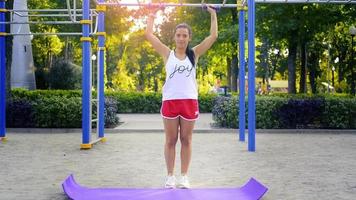 adult caucasian woman train her biceps with dumbbells at warm sunny day at the park video