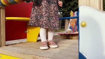 close up of little baby legs on a childrens playground at warm summer day video