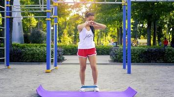 brunette caucasian sports woman balance la jambe à la salle de gym de la rue au chaud jour d'été video