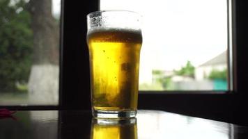 close up of cold fizzy beer in a transparent glass on the table video