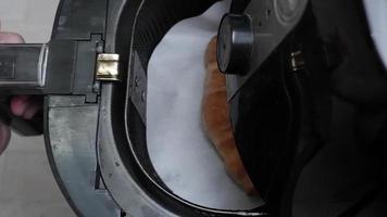 A man's hand opens a hot air oven with croissant bread inside. hot baking video