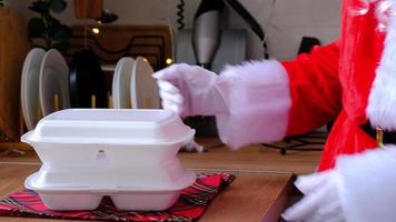 Food delivery to home service containers in hands of Santa Claus puts it on kitchen table and takes it away. Ready-made hot order, Christmas, New year holidays catering. video