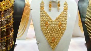 Dubai, UAE, 2022 - various golden luxury arabic style necklaces in old gold souk shop in old Dubai video