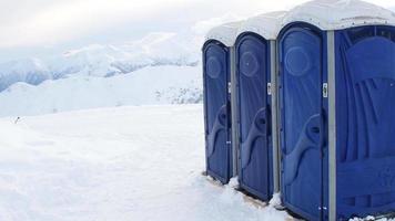 Portable three blue toilets for skiers ski resort clients on top of mountain in Gudauri winter ski resort video