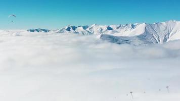 mensen paragliden tandem bovenstaand berg in winter in Georgië ski toevlucht. concept van actief levensstijl en extreem sport avontuur. video