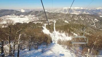 antenne passagiers punt van visie van stoeltjeslift gaan omhoog in winter bakuriani ski toevlucht in Georgië. beroemd reizen bestemming voor buitenshuis skiën video