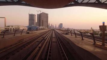 dubai, emirados árabes unidos, 2022 - trem de metrô na ferrovia em dubai com museu do futuro e fundo de edifícios futuristas. fpv pov em movimento de unidade de alta velocidade. metrô sem motorista