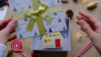 sleutel naar huis met sleutelhanger Aan knus huis in geschenk doos met Kerstmis decor verpakking. pak Cadeau voor nieuw jaar, kerstmis. gebouw, projecteren, in beweging naar nieuw huis, hypotheek, huur, aankoop echt landgoed video