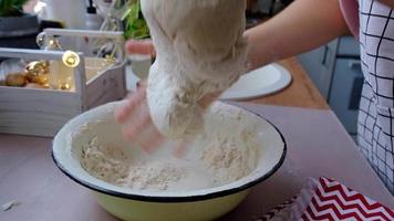 Hands knead thick dough on the kitchen table, decorated with festive decorations for Christmas and New year. Baking at home, aroma and comfort. Close-up video